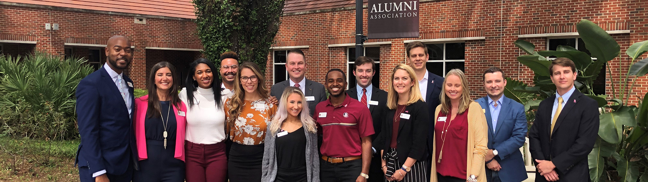 Young Alumni Council standing in front of Alumni Hall