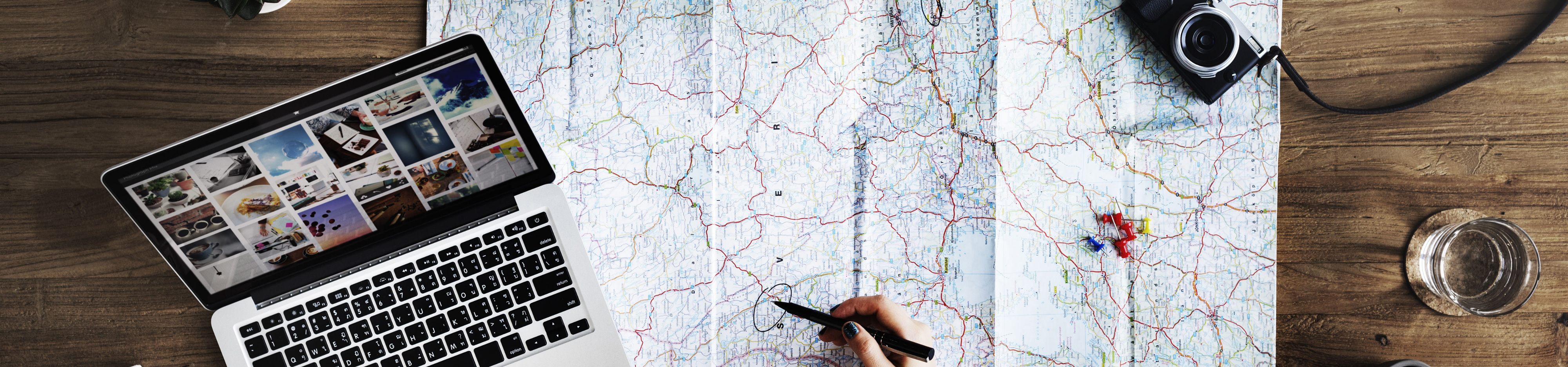 Picture of a travel map and a laptop on a desk