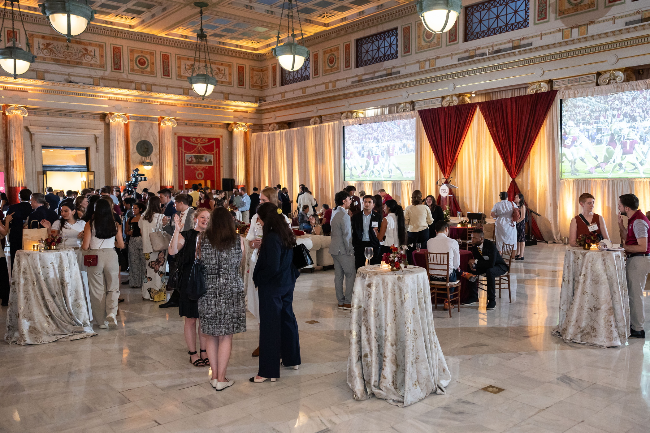 A photo of a number of people gathered in a ballroom