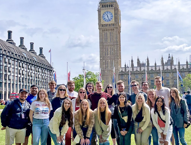 A photo of a group of young alumni in London, with Big Ben prominently in the background